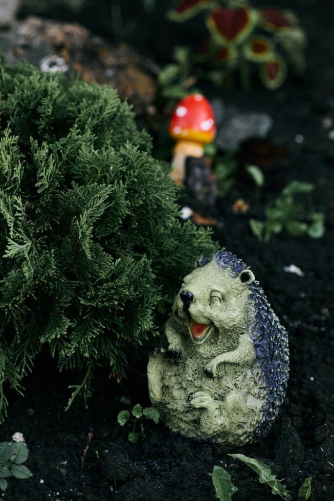 Whimsical garden scene featuring a hedgehog statue and mushroom decor.